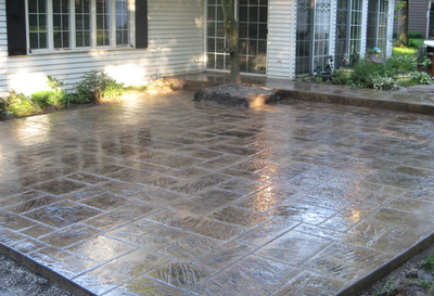 Polished dark gray stone shaped stamped patio.