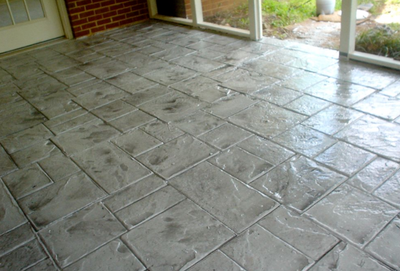Polished gray stamped concrete indoor patio.
