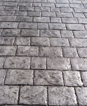 Dark gray stamped concrete made to resemble old weathered brick.